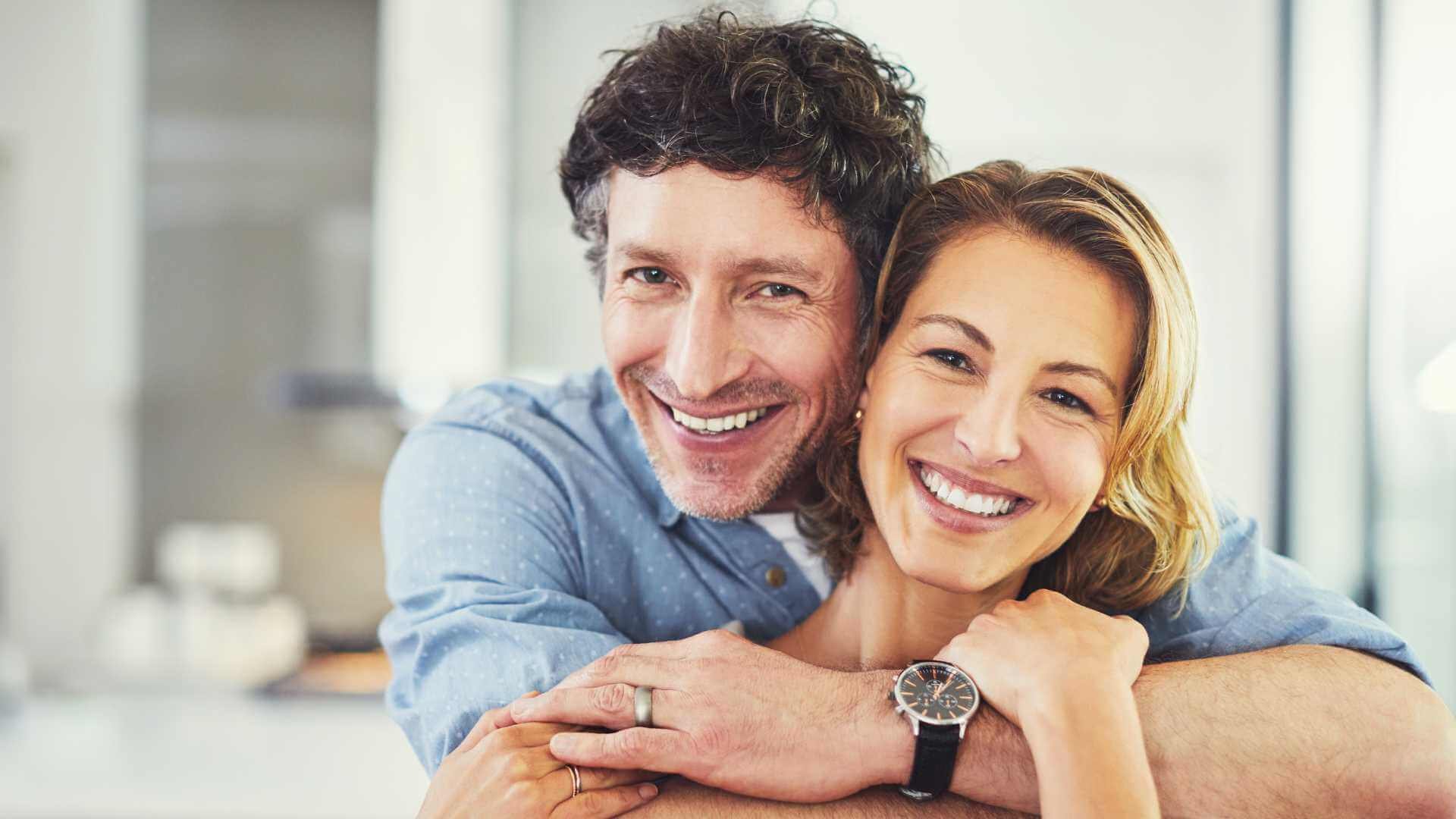 A couple embracing in a kitchen.